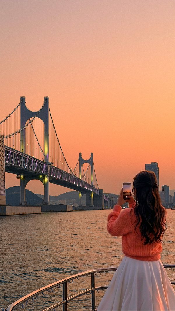 Guest taking sunset photos facing Gwangan Bridge