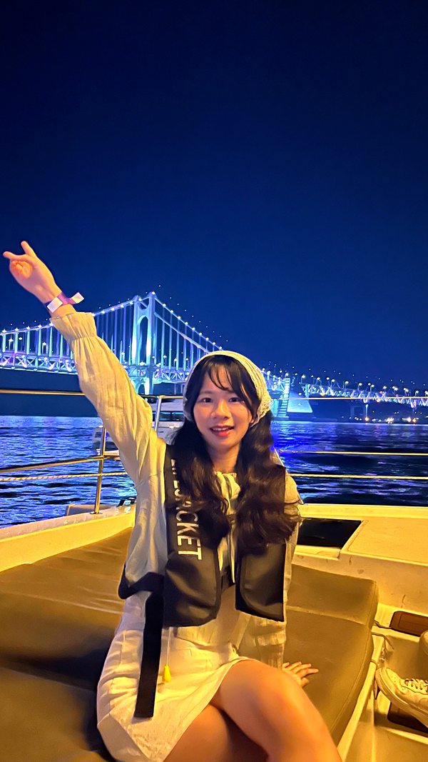 Guest raising a hand on the cruise deck in front of the night view