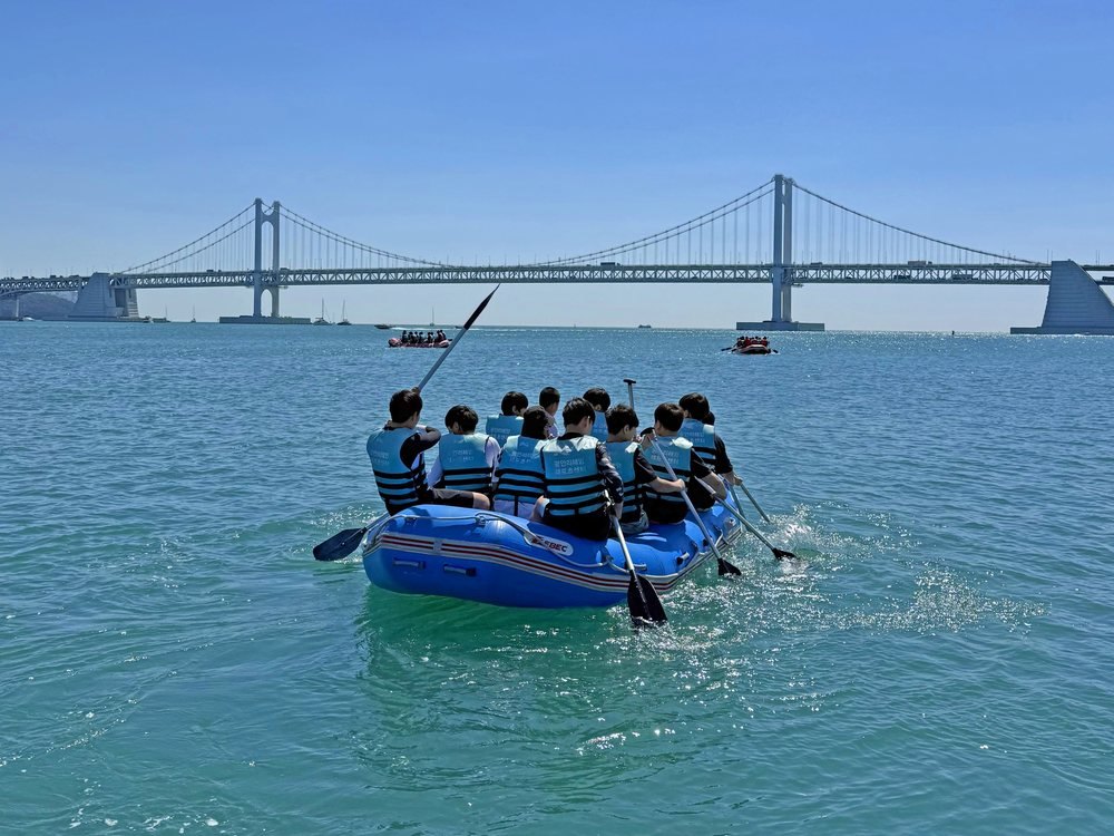 People rafting with Gwangan Bridge behind