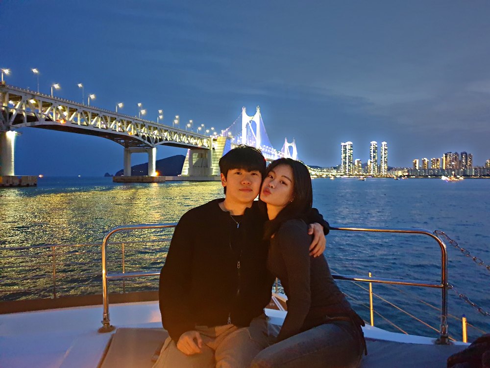 Couple on the cruise deck in front of the Gwangan Bridge night view