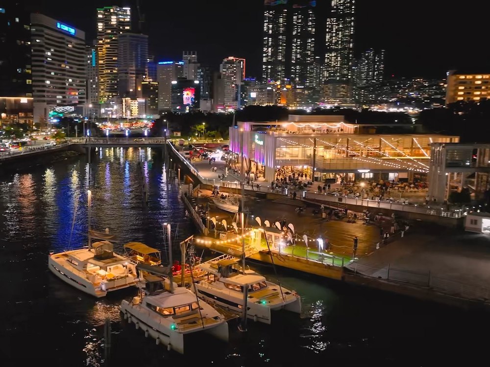 The Bay 101 building at night and yachts moored at the marina